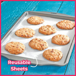 Baking tray with cookies on a reusable nonstick baking sheet, blue wooden table background
