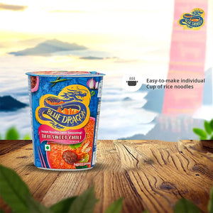 Blue Dragon Thai Sweet Chilli instant noodles cup on wooden surface with scenic mountain background