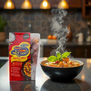 Steaming bowl of Thai red curry with basil next to Blue Dragon Thai Red Curry kit on kitchen counter