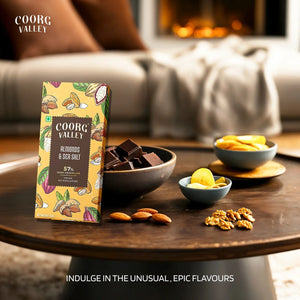 Coorg Valley almonds & sea salt dark chocolate bar with chunks, almonds, and walnuts on a wooden table
