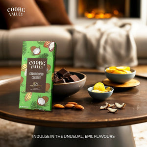 Coorg Valley caramelized coconut 57% dark chocolate bar on table with chocolate pieces, almonds, coconut slices, and snacks