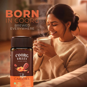 Woman enjoying a cup of coffee with Coorg Valley Toffee Caramel instant coffee in foreground.