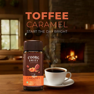 Coorg Valley Toffee Caramel instant coffee jar with a steaming cup on a wooden table, cozy indoor setting.
