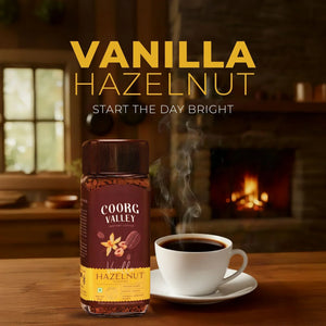 Coorg Valley Vanilla Hazelnut instant coffee jar and steaming cup on table, cozy fireplace background