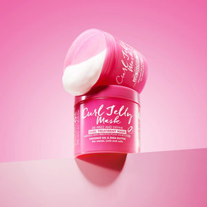 Curl Jelly Mask hair treatment jar with coconut oil and shea butter on pink background