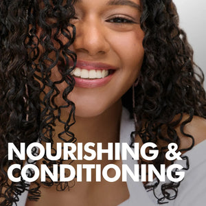 Close-up of smiling woman with healthy curly hair highlighting nourishing and conditioning hair care