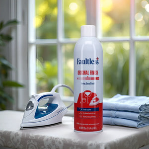 Faultless Original Finish ironing spray starch can with steam iron on ironing board near folded clothes