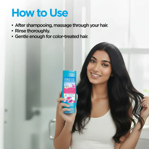 Smiling woman with long black hair holding Finesse Moisturizing Conditioner bottle in bright bathroom
