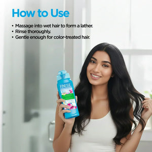 Woman with long hair holding Finesse Volumizing Shampoo in a bathroom, haircare instructions visible