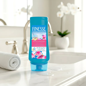 Finesse moisturizing conditioner bottle on bathroom counter near towel and sink faucet