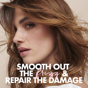 Close-up of a woman with wavy brown hair, text reads smooth out the frizz and repair the damage for hair care