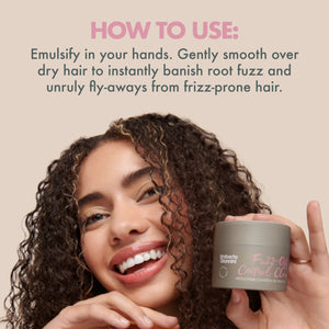 Smiling woman with curly hair holding Umberto Giannini Fuzz-Off Control Clay for frizz-prone hair with usage instructions
