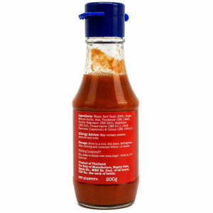 Glass bottle of hot chili sauce with blue cap and red label showing ingredients and usage instructions