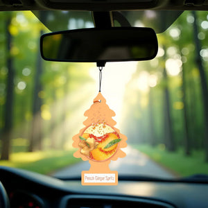 Little Trees Peach Ginger Spritz air freshener hanging in a car with a forest backdrop