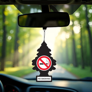 No smoking car air freshener hanging from rearview mirror with forest road background