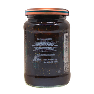 Glass jar of fig preserve with visible fig seeds, nutrition label, and copper lid