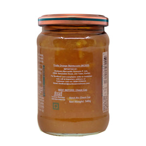 Glass jar of fruity orange marmalade with visible orange pieces and product label on back