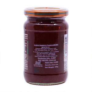 Glass jar of Scottish Raspberry Preserve with orange lid and product details label