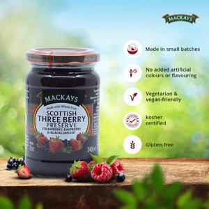 Jar of Mackays Scottish Three Berry Preserve with strawberries, raspberries, blackcurrants on wooden surface