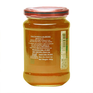 Glass jar of Three Fruit Marmalade with red lid, showing product label and barcode