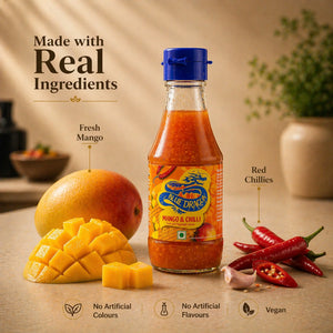 Bottle of Blue Dragon Mango & Chilli sauce with fresh mango cubes and red chillies on a kitchen counter
