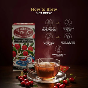 Cranberry tea box and glass cup with tea bag, fresh cranberries, and hot brew instructions.