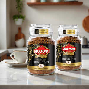 Two jars of Moccona Indulgence 8 instant coffee on kitchen counter with cup and saucer in background