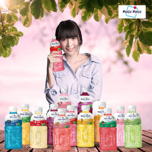 Smiling woman holding Mogu Mogu pink drink surrounded by various colorful Mogu Mogu fruit juice bottles