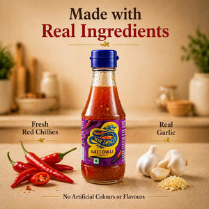 Blue Dragon sweet chilli sauce bottle with fresh red chillies and garlic on kitchen counter