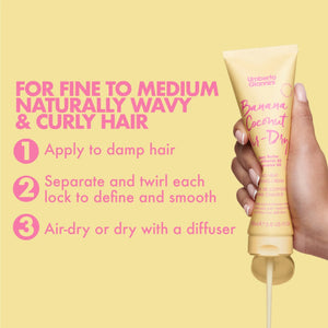 Hand holding Umberto Giannini Banana Coconut Air-Dry Styling Cream with application instructions for wavy curly hair