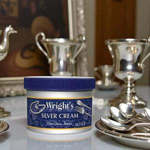 Wright's Silver Cream container with polished silver trophies and spoons on table