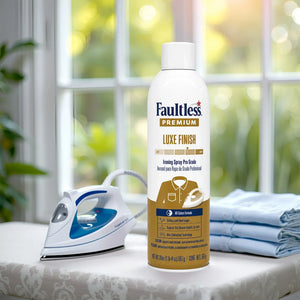Faultless Premium Luxe Finish ironing spray with steam iron and folded shirts on ironing board near window