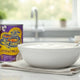Coconut milk cans with fresh coconut, bowl of coconut milk, and spices on a kitchen counter