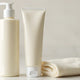 Hand cream and lotion bottles with towel on bathroom counter, skincare products scene