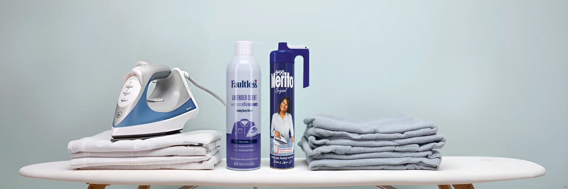 Steam iron, Faultless Lavender Scent spray starch, and Merito Original fabric spray on ironing board with folded linens
