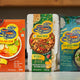 Blue Dragon Tom Yum Soup, Chow Mein & Thai Green Curry kits with fresh veggies in kitchen