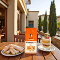 Outdoor table with Vicenzi Vicenzovo ladyfinger biscuits, packaged cookies, and layered dessert with raspberries