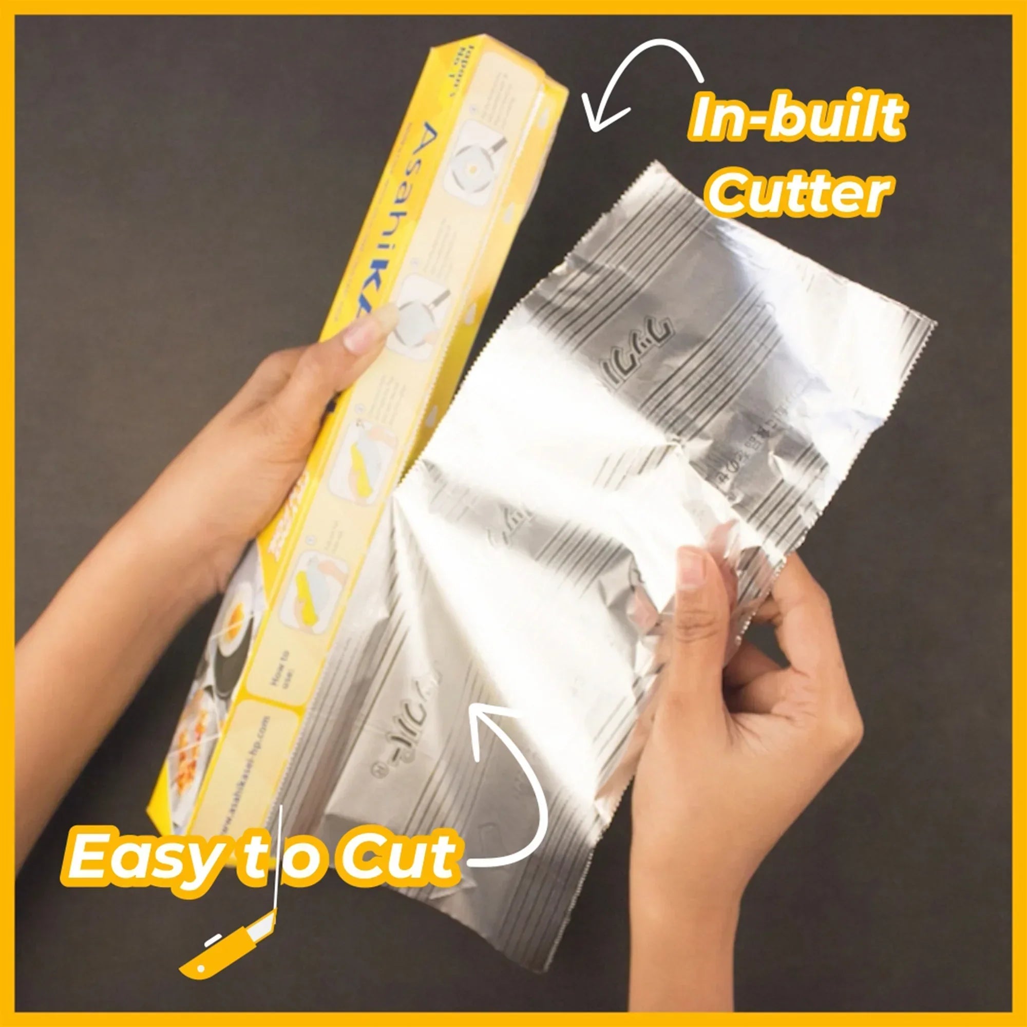 Hands using kitchen foil with in-built cutter, easy to cut, on black surface