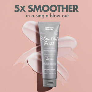 Umberto Giannini Blow Out Frizz Styling Cream tube on pink background with cream smears, anti-frizz hair care