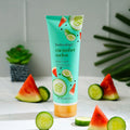 Bodycology cucumber melon body cream with watermelon and cucumber slices on a white surface.