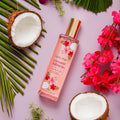 Bodycology coconut hibiscus perfume bottle with coconuts and flowers on a pink background