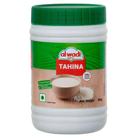 Jar of Al Wadi Tahina with green lid on a white background