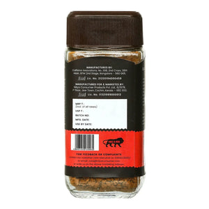 Back view of a spice or tea jar with brown lid, product details label, and transparent bottom showing contents.