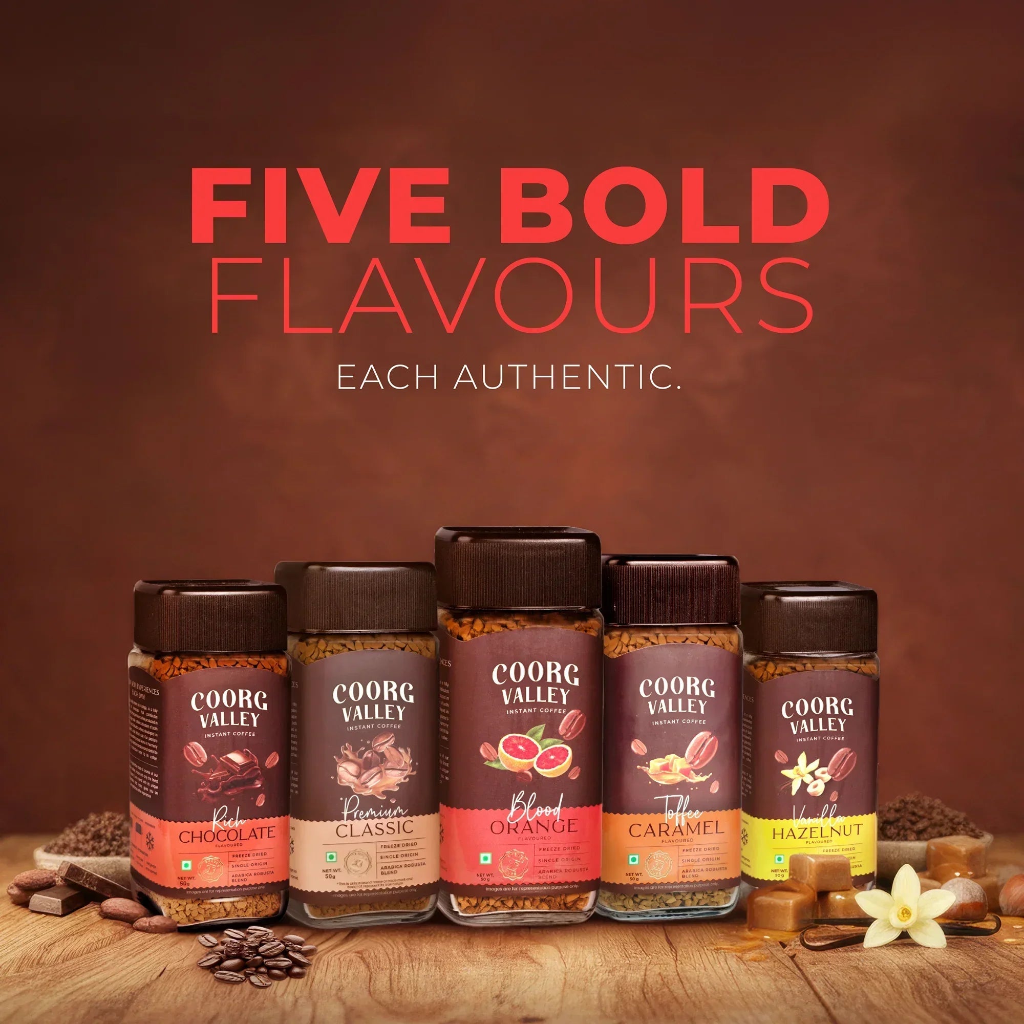 Five Coorg Valley instant coffee jars in assorted flavors, arranged on a rustic wooden table.