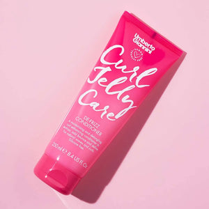 Pink tube of Umberto Giannini Curl Jelly Care De-Frizz Conditioner on pink background