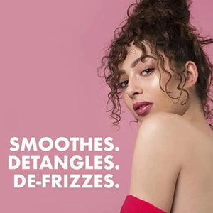 Curly-haired woman with smooth skin on pink background, text reads Smoothes, Detangles, De-Frizzes hair