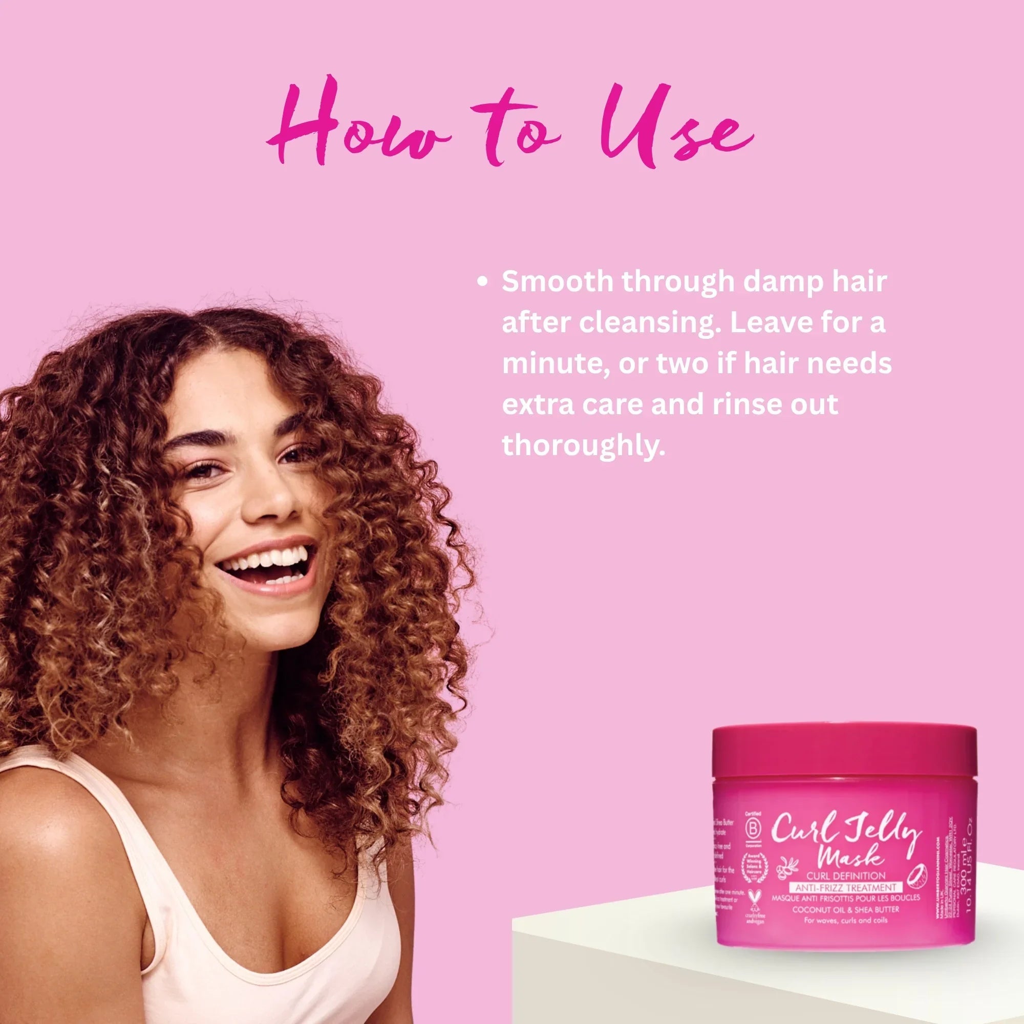 Smiling woman with curly hair next to pink Curl Jelly Mask hair care product on pink background