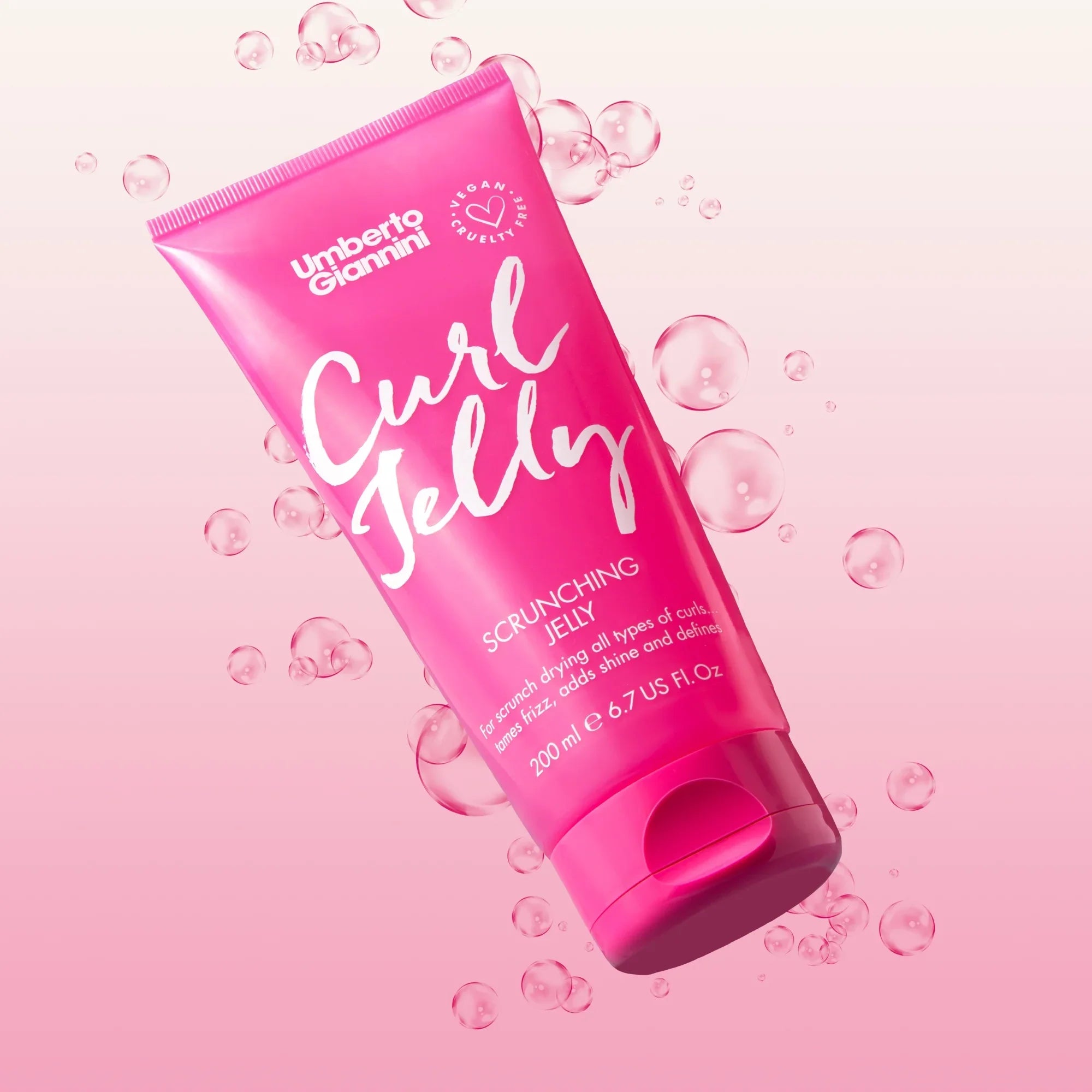 Umberto Giannini Curl Jelly Scrunching Jelly hair product tube in pink with bubbles on pink background