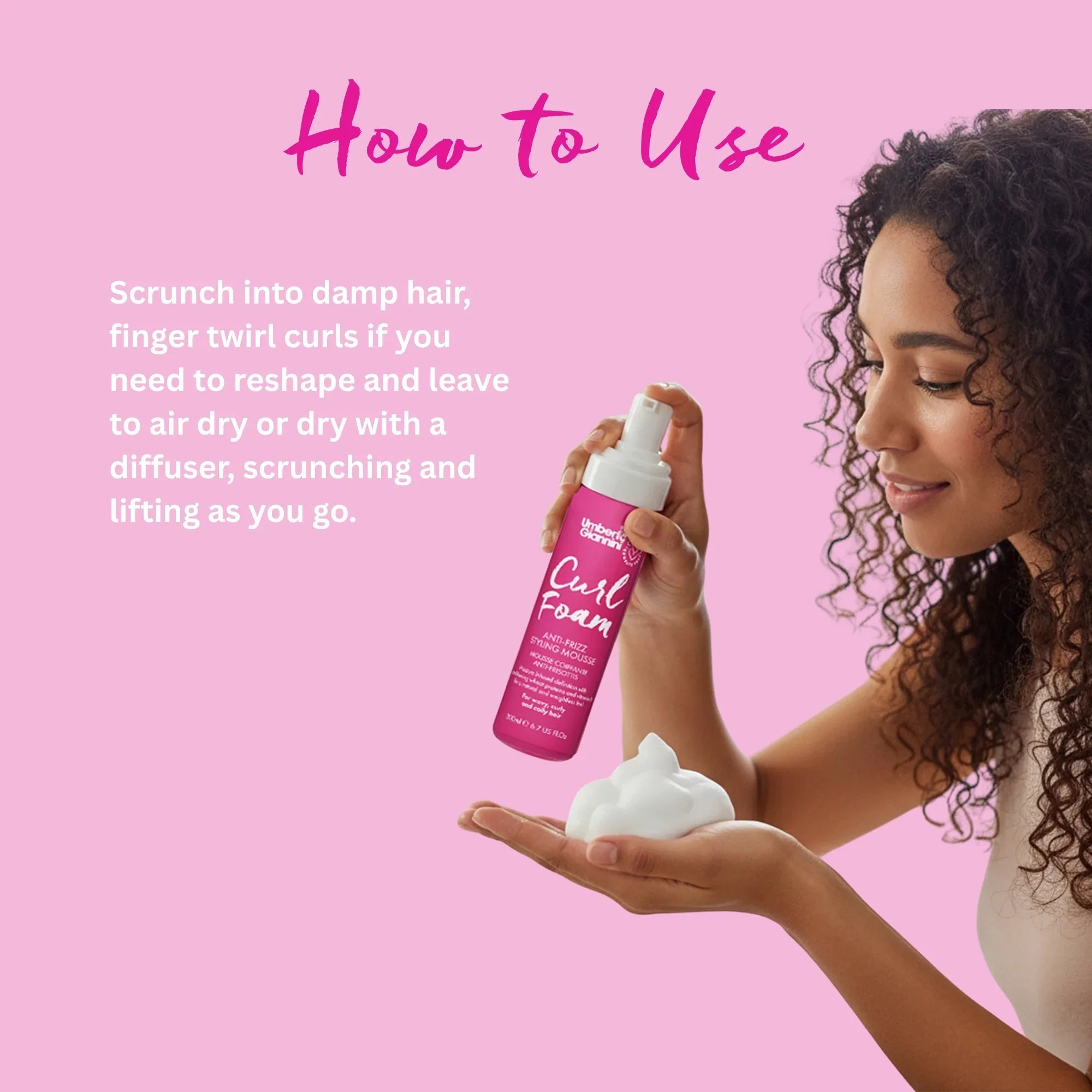 Woman with curly hair holding pink Umberto Giannini Curl Foam anti-frizz styling mousse on pink background with usage instructions