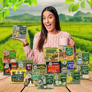 Smiling woman holding Earl Grey green tea box with assorted tea boxes on table and tea plantation background